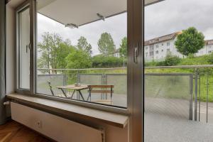 キッツィンゲンにあるApartmenthaus Kitzingen - großzügige Wohnungen für je 4-8 Personen mit Balkonの窓とテーブル付きのバルコニーが備わる客室です。