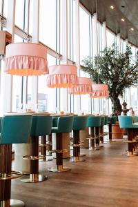 a row of chairs in a restaurant with windows at INNSiDE by Meliá Amsterdam in Amsterdam