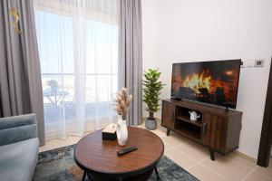 sala de estar con TV y mesa de centro en Luminous 1BR Apartment Al reem, en Abu Dabi