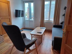 sala de estar con silla y mesa en Schlossblick Apartment für 4 mit Küche Kamin Netflix Parken und Hofladen en Steinhöfel