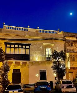 um edifício com carros estacionados em frente em The Siggiewi Suites em Siġġiewi