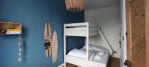 a white bunk bed in a room with a surfboard at Rev d’Opale in Wimereux