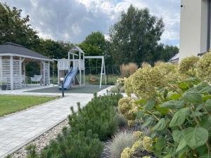 een speeltuin met een glijbaan in een tuin bij Jantarnia in Jantar