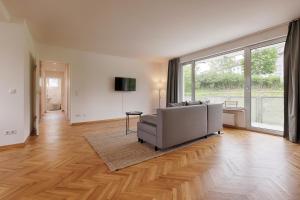基青根的住宿－Apartmenthaus Kitzingen - großzügige Wohnungen für je 4-8 Personen mit Balkon，带沙发和大窗户的客厅