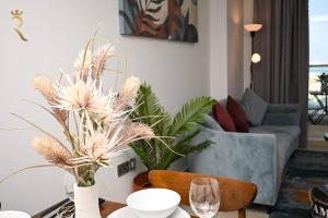 a living room with a table with flowers and a couch at Luminous 1BR Apartment Al reem in Abu Dhabi