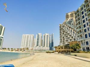 a beach in front of some tall buildings at Luminous 1BR Apartment Al reem in Abu Dhabi