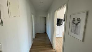 a hallway with white walls and a hallway with a mirror at Air Apartments 1 in Bremen