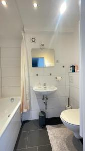 a white bathroom with a sink and a toilet at Air Apartments 1 in Bremen