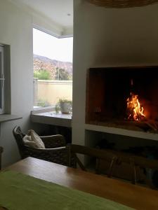 a living room with a fireplace and a table at Sage in Montagu