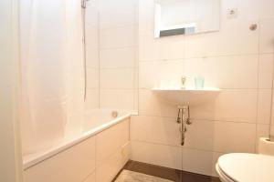 a white bathroom with a sink and a toilet at Air Apartments 1 in Bremen