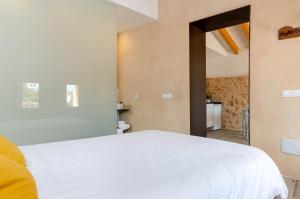 a bedroom with a white bed and a bathroom at Cal Tio 2 Agroturismo YourHouse in Costitx