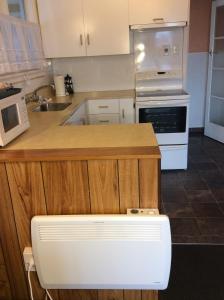 eine Küche mit einer Holztheke und einem weißen Gerät in der Unterkunft Belle Bonne Motel in Christchurch