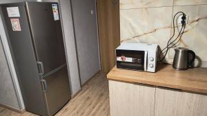 uma cozinha com um micro-ondas e um frigorífico em Pokoje Gościnne u Marka em Tuszyn