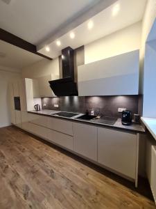 a large kitchen with white cabinets and a wooden floor at Ferienhaus Take it easy in Traben-Trarbach