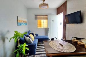 a living room with a blue couch and a table at Apartamento acogedor Ashmi in Santiago de los Caballeros