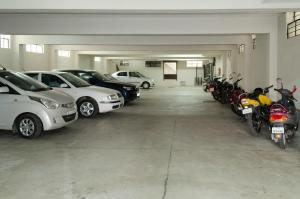 a garage with cars and motorcycles parked in it at Kohinoor Hotels in Erode