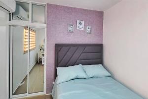 a bedroom with a bed and a purple wall at Apartamento acogedor Ashmi in Santiago de los Caballeros