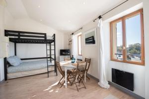 een slaapkamer met een tafel en een stapelbed bij L'Isle en Blanc - Appartement hypercentre - 4 couchages in LʼIsle-sur-la-Sorgue