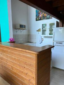 a kitchen with a wooden counter with a refrigerator at Le Neem in Saint-François +49 photos