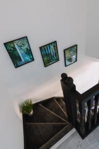 a staircase with three pictures on the wall and a plant at Emirates ApartHOUSE in Glasgow