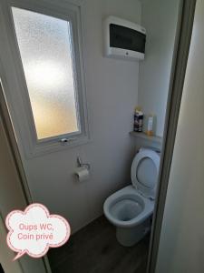 a small bathroom with a toilet with a window at Mobil-home cosy 166 in Narbonne