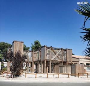 a building with a wooden structure in the middle at Mobil-home cosy 166 in Narbonne