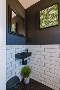 格拉斯哥的住宿－Emirates ApartHOUSE，浴室设有黑色水槽和镜子