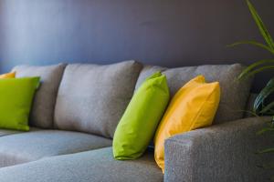 four yellow and green pillows on a couch at Emirates ApartHOUSE in Glasgow