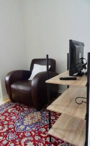a living room with a brown leather chair and a desk at Studio in the center area with free street parking in Vaasa