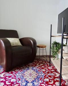 a living room with a brown leather couch and a television at Studio in the center area with free street parking in Vaasa