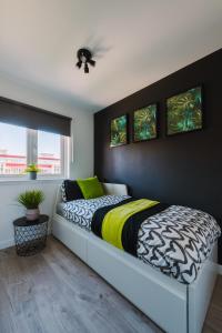 格拉斯哥的住宿－Emirates ApartHOUSE，一间卧室配有一张带黑色和黄色棉被的床