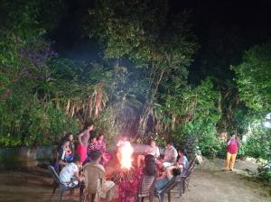 a group of people sitting around a fire at Munnar home stay Teadrops plantation villa in Munnar
