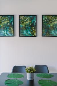 a meeting room with a table with four paintings at Emirates ApartHOUSE in Glasgow