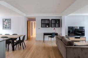 ein Wohnzimmer und ein Esszimmer mit einem Sofa und einem Tisch in der Unterkunft Law & Order - Farringdon - by Frankie Says in London