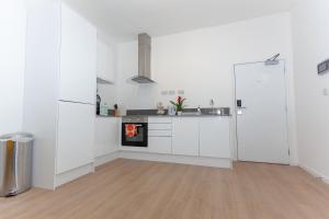 a white kitchen with white cabinets and a fireplace at One Bedroom Apartment Smethwick Flat 308 in Birmingham
