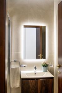 a bathroom with a sink and a mirror at The Siggiewi Suites in Siġġiewi