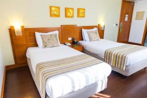 Habitación con 2 camas en una habitación de hotel en Quality Porto Alegre, en Porto Alegre