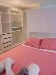 um quarto com uma cama rosa e prateleiras abertas em New Apartament close to IFEMA-AEROPUERTO em Madri