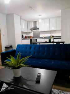a living room with a blue couch and a table at Urban 2 Bedroom with Parking in West Bromwich