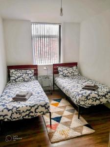 a bedroom with two beds and a window at Urban 2 Bedroom with Parking in West Bromwich