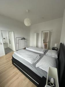 2 łóżka w sypialni z białymi ścianami i drewnianą podłogą w obiekcie Air Apartments 3 w Bremie