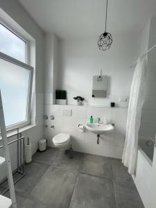 a white bathroom with a toilet and a sink at Air Apartments 3 in Bremen