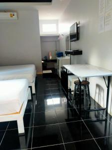 Zimmer mit 2 Betten, einem Schreibtisch und einem Tisch in der Unterkunft Nemo 2 Resort in Ao Nang Beach