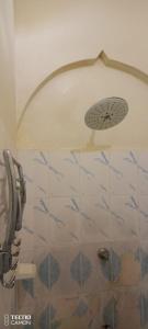 een douche met een douchekop in de badkamer bij New Mahrus Hotel Lamu in Lamu