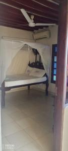 un piccolo letto in una camera con soffitto di New Mahrus Hotel Lamu a Lamu