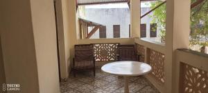 a small table and chairs on a balcony at New Mahrus Hotel Lamu in Lamu