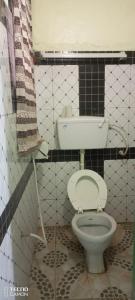 een badkamer met een toilet in een zwart-wit betegelde kamer bij New Mahrus Hotel Lamu in Lamu