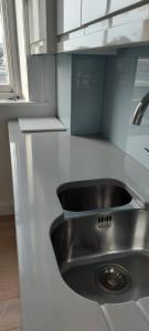 a kitchen with a sink in the middle of a counter at Elegant 1st Floor 1BR Belsize Park Apartment in London
