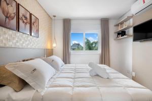 Ένα ή περισσότερα κρεβάτια σε δωμάτιο στο Apto 2 Suítes 30m Rua Coberta by Achei Gramado