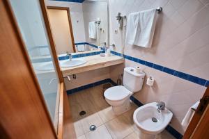 a bathroom with a toilet and a sink and a mirror at Hotel Varandas do Atlântico by RIDAN Hotels in Praia da Vitória